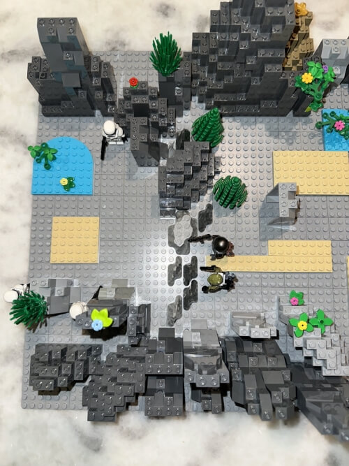 LEGO encounter — party climbing over rocky terrain before the ambush triggers