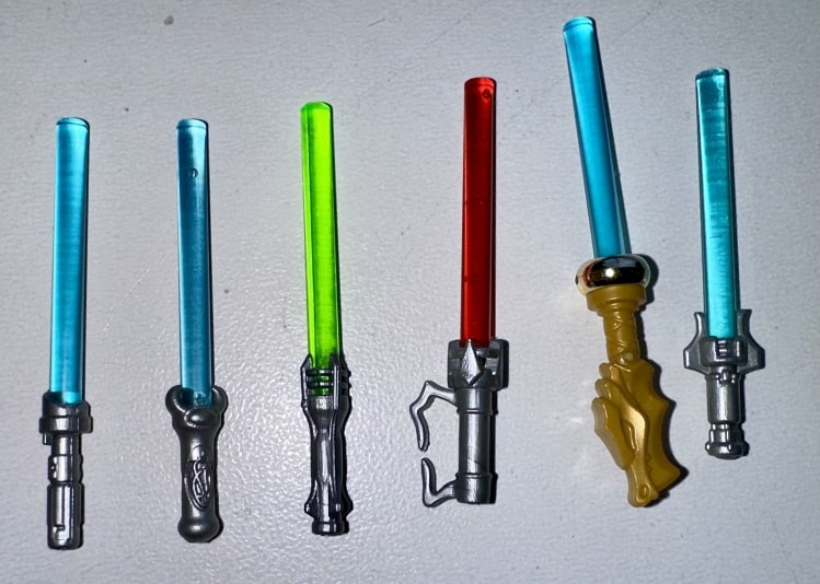 Various LEGO lightsaber hilts showing different colors, grips, and Jedi/Sith styles